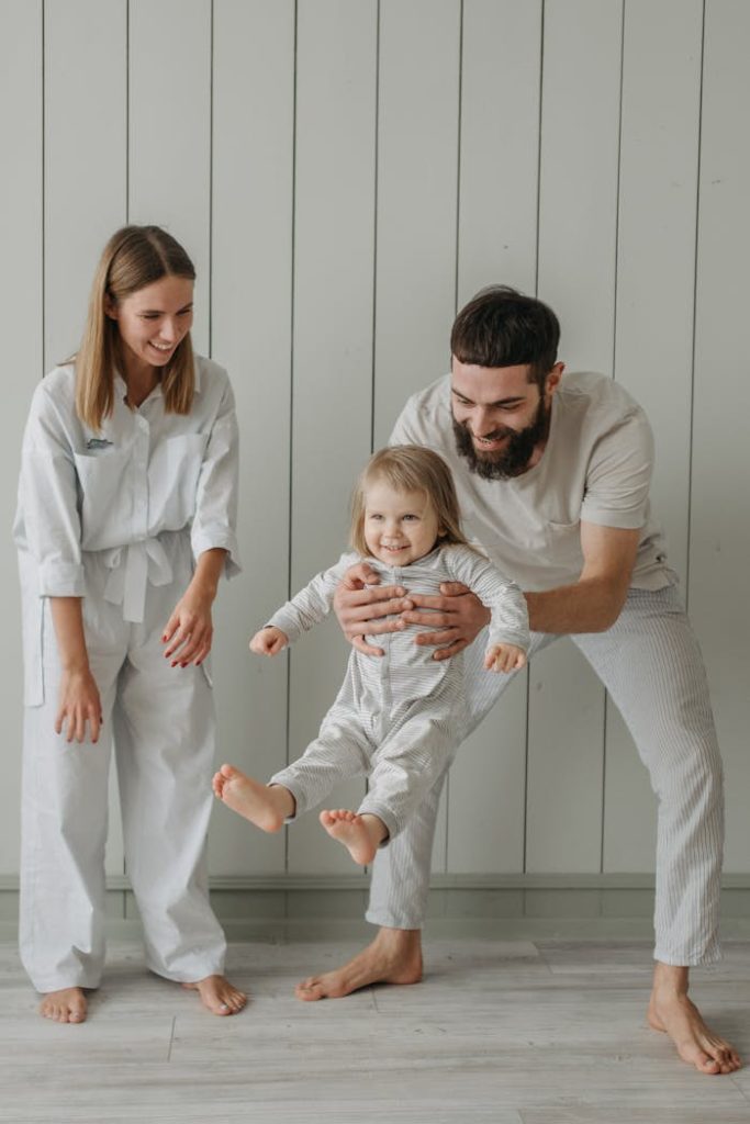 A Father Carrying His Child Near a Woman